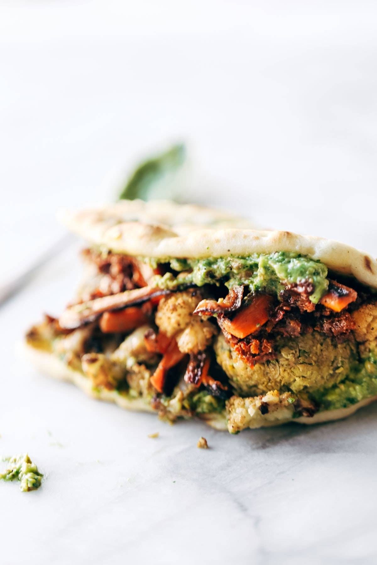 Naan-wich: 5 ingredient falafel, roasted veggies, and avocado sauce stuffed between pillowy garlic naan. Best sandwich recipe I've ever made. | pinchofyum.com