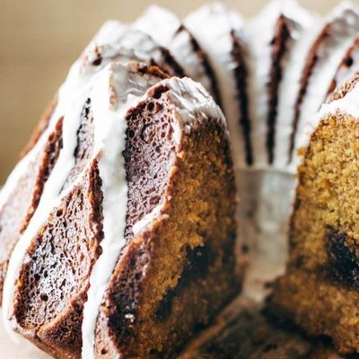 Pumpkin Bundt Cake on cake stand with glaze.